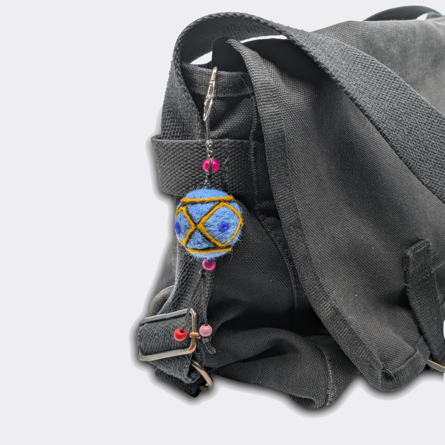 Breloque de sac Borka avec fond bleu attachée sur un sac