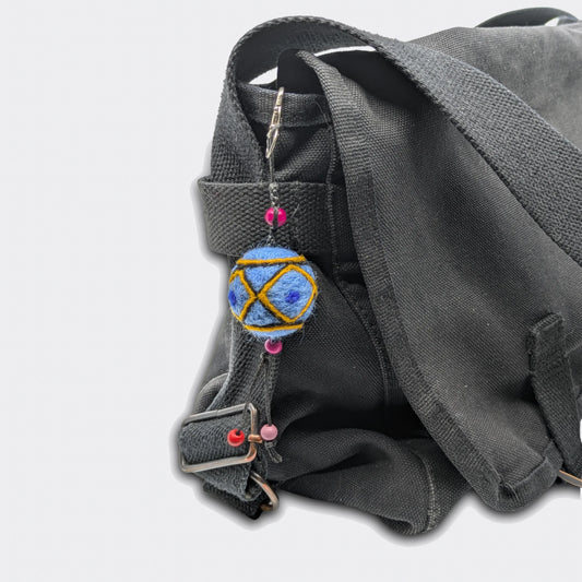 Breloque de sac Borka avec fond bleu attachée sur un sac