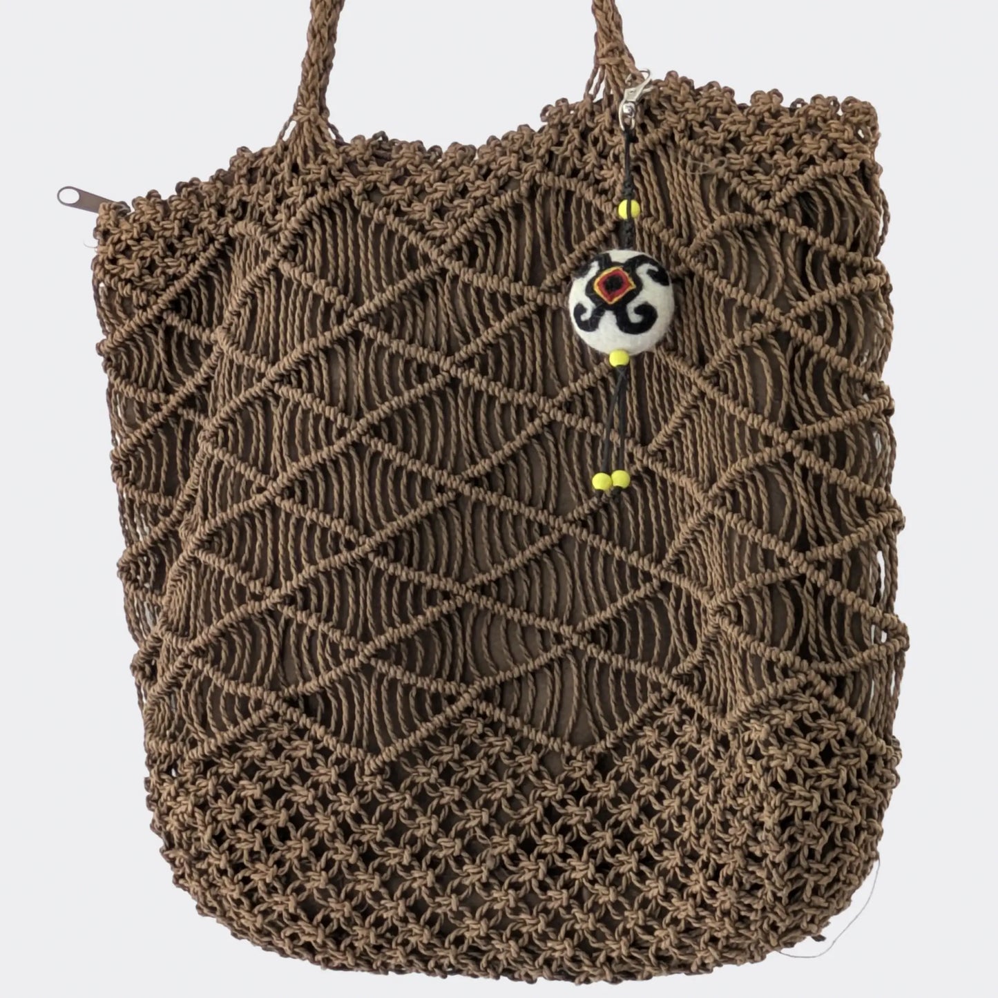 Accessoire de sac en feutre artisanal accroché à un sac en corde