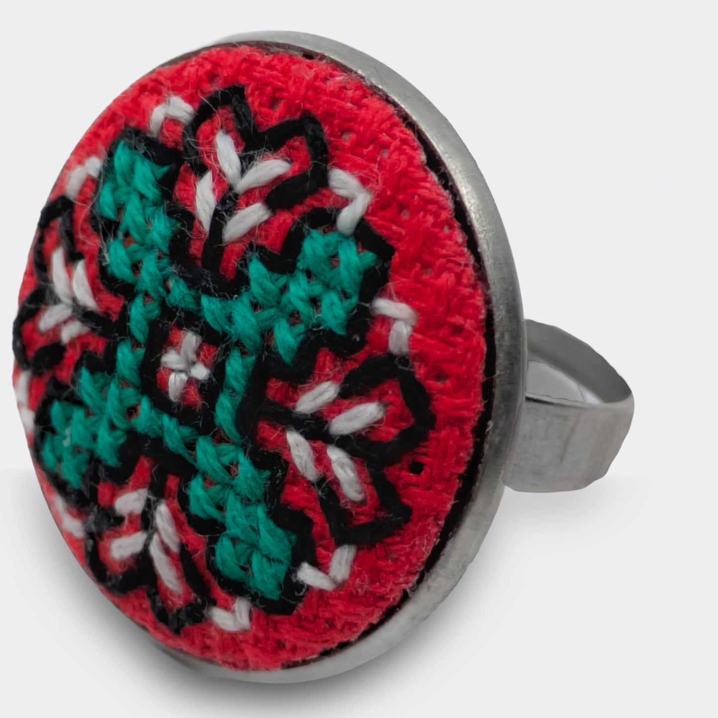 Motif brodé rouge et vert appliqué sur plateau rond. Une bague brodée qui apporte une touche colorée.
