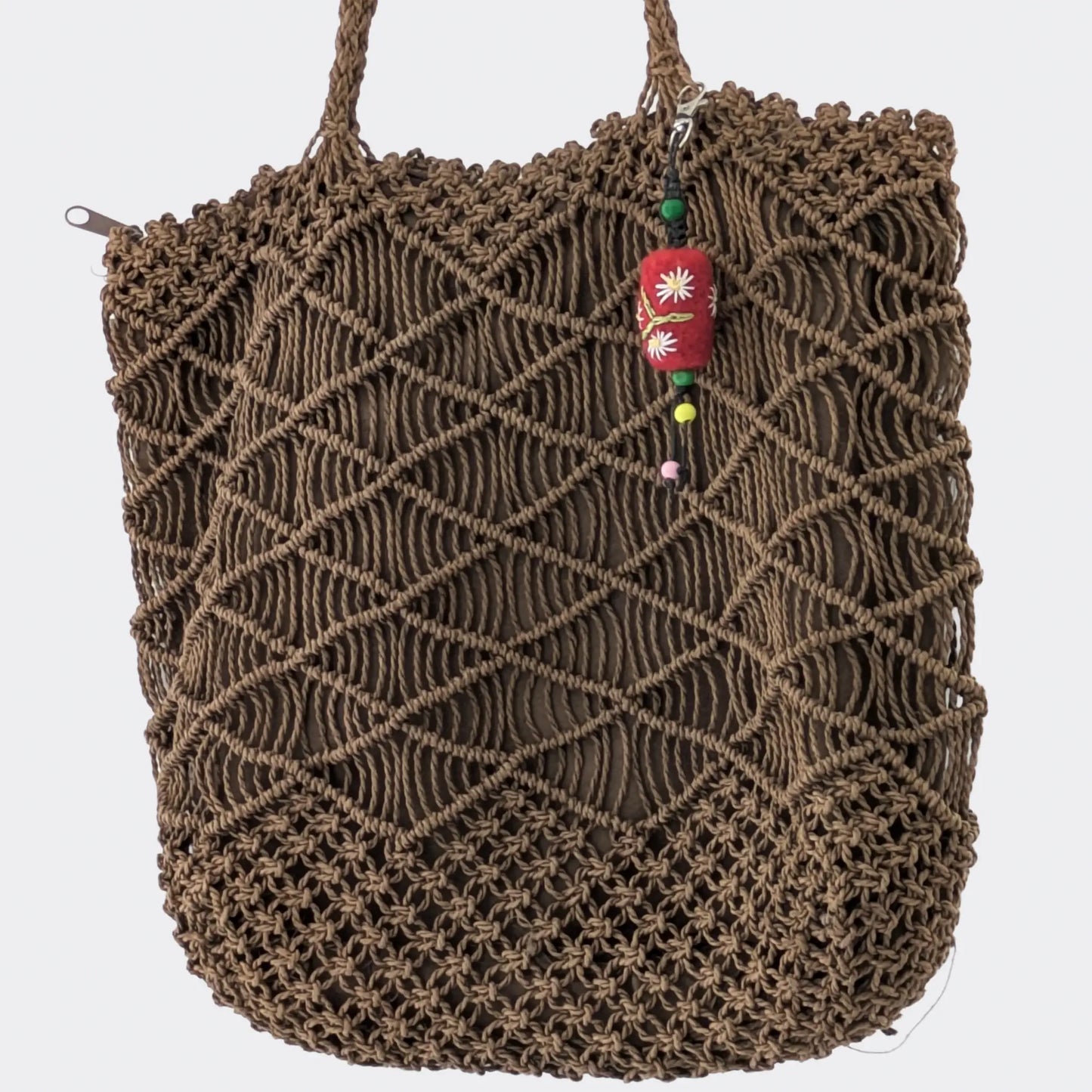 Bijou de sac issu de l’artisanat balkanique présenté sur sac en corde