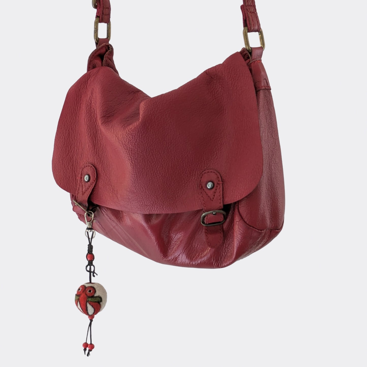 Breloque de sac en feutre de laine faite main sur sac rouge