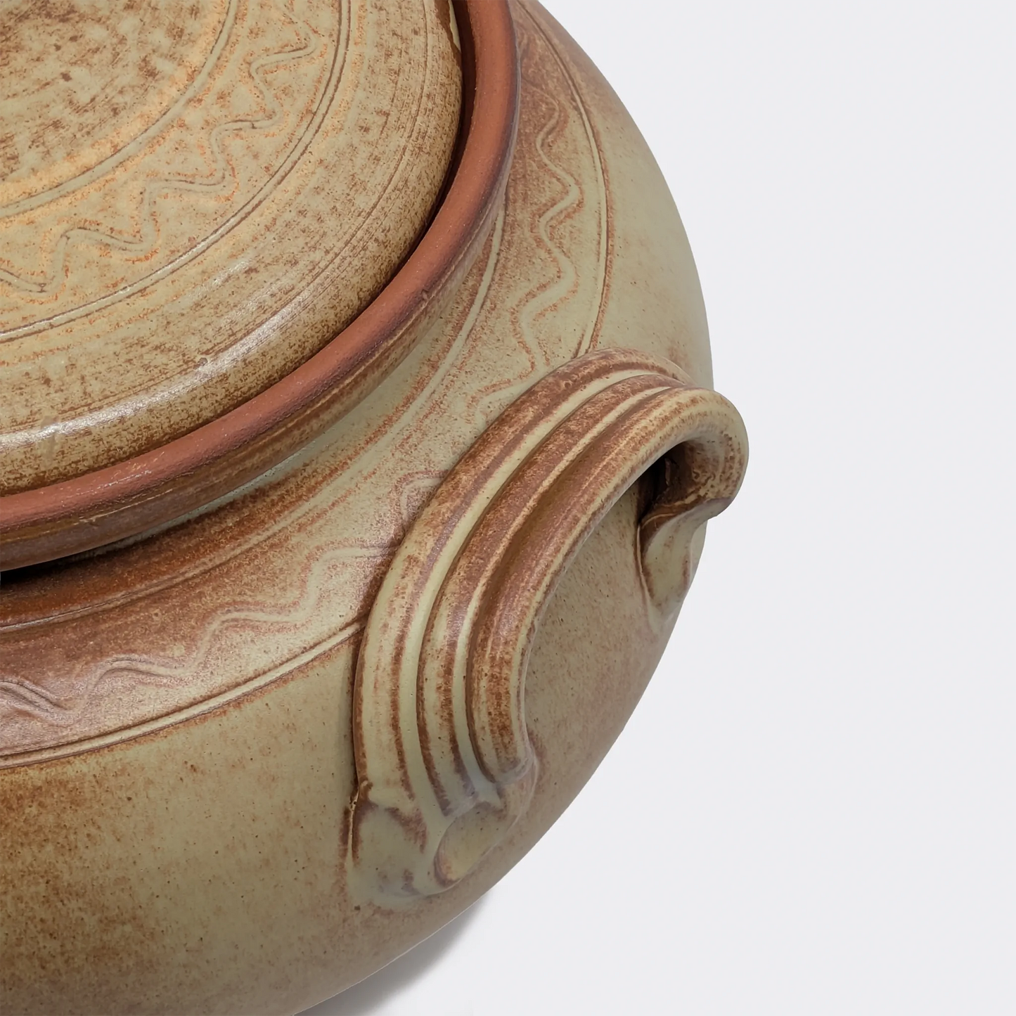 Gros plan sur le couvercle et la poignée d’une cocotte en terre cuite 10 litres fabriquée artisanalement à Corund.