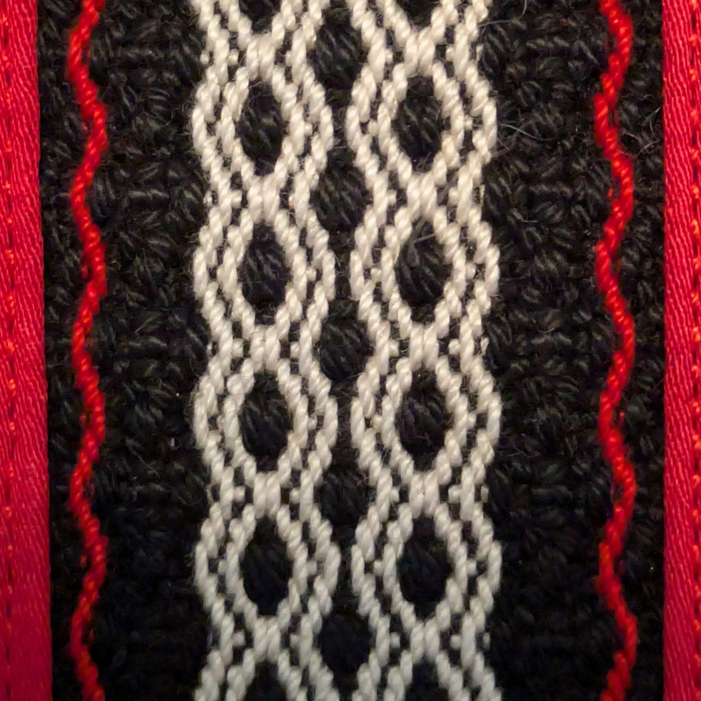 Détail de la trame centrale tissée de la trousse rouge.