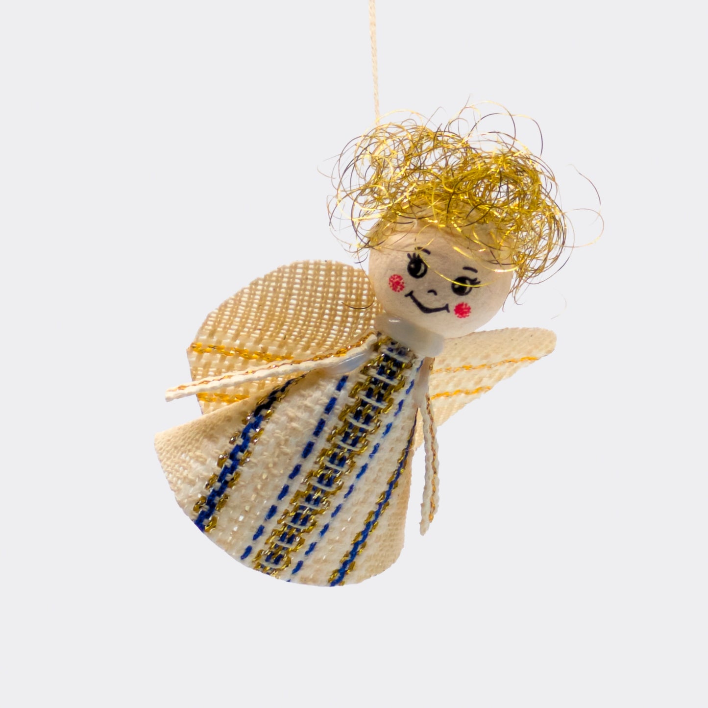 Suspension d’angelot bleu foncé en textile artisanal. Les fils dorés et la robe tissée évoquent l’art domestique tchèque. Une petite décoration pour l’hiver.