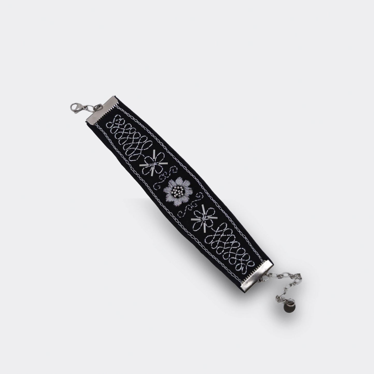 Bracelet artisanal brodé noir avec décor argenté, mélange de point de chaînette et de point plein. Style balkanique moderne et traditionnel, vue du haut