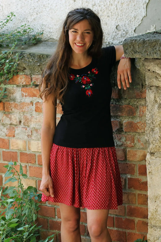 Les broderies hongroises si caractéristiques ornent ce Tshirt noir à manches courtes. Le noir profond de ce vêtement met en valeur les couleurs vives de la broderie. Vue plus éloignée.