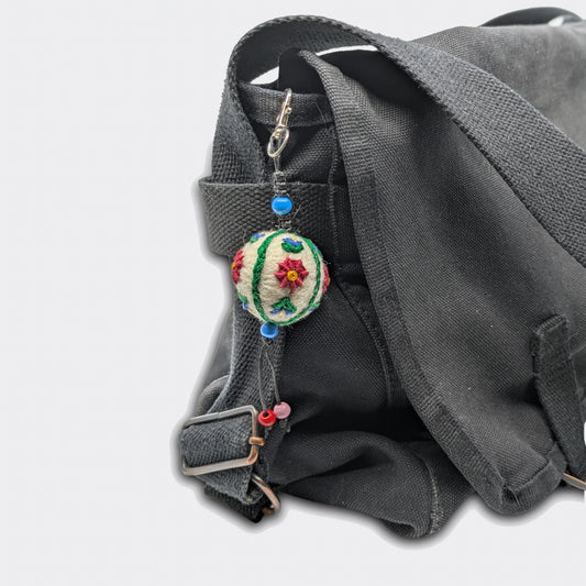Breloque Vladislava accrochée sur sac, motif floral sur petite boule en feutre