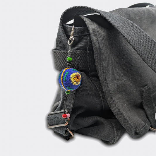 Suspension décorative Zlata avec petite boule en feutre bleue nuit et tournesols brodés. Sur sac.