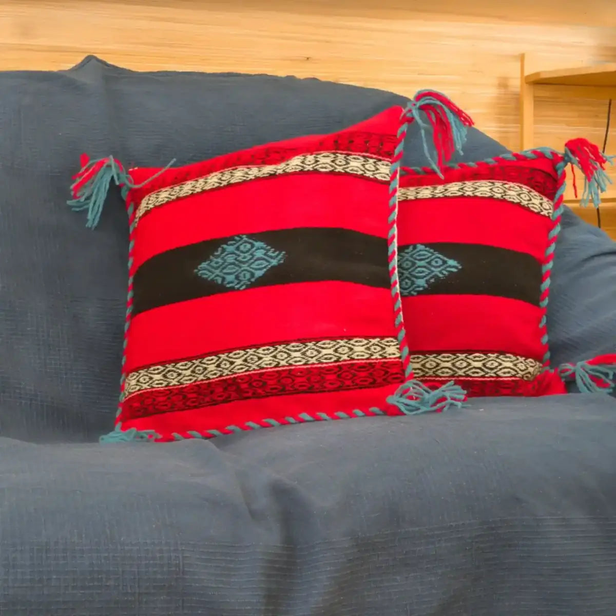 Coussins rouges typiquement slaves, tissés manuellement en Serbie. Sur un canapé.