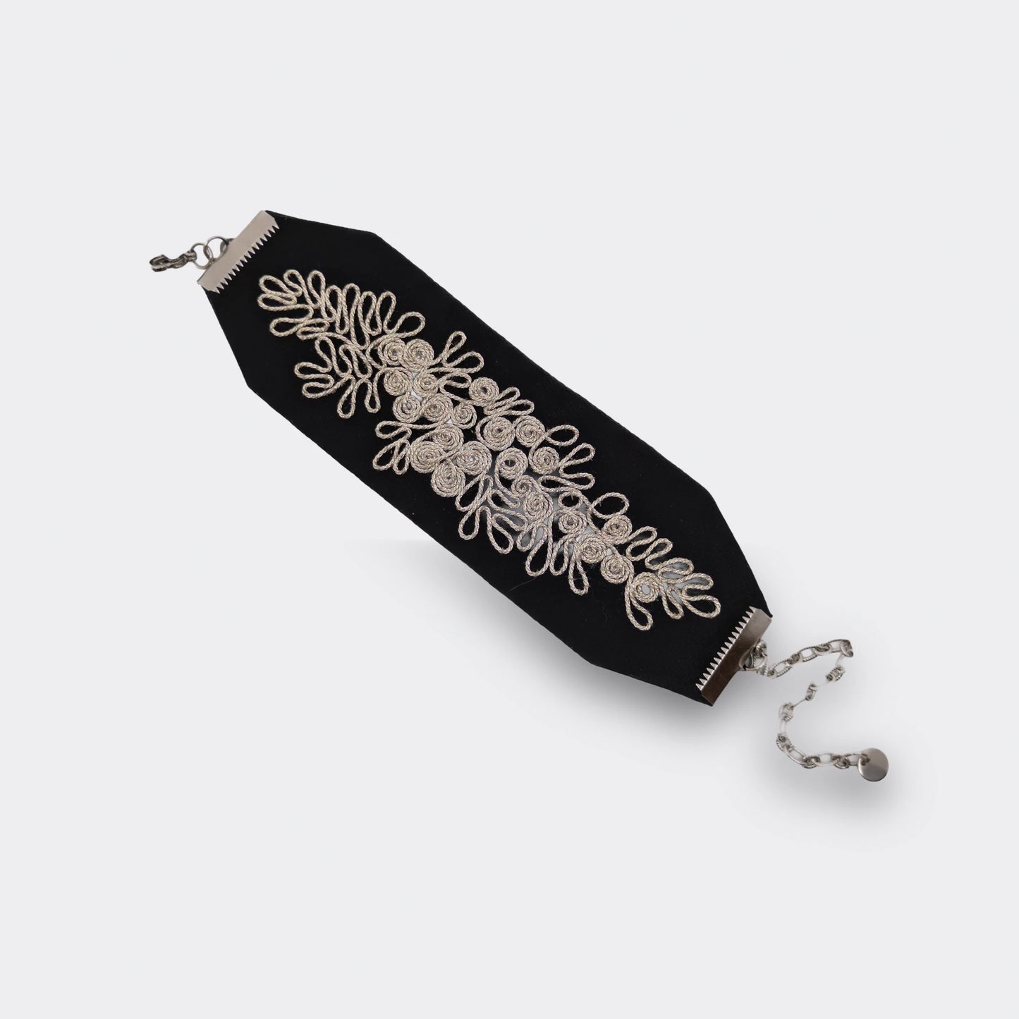 Bracelet textile noir brodé main avec un fil argenté. Les attaches métalliques en acier hypoallergénique. Modèle large.