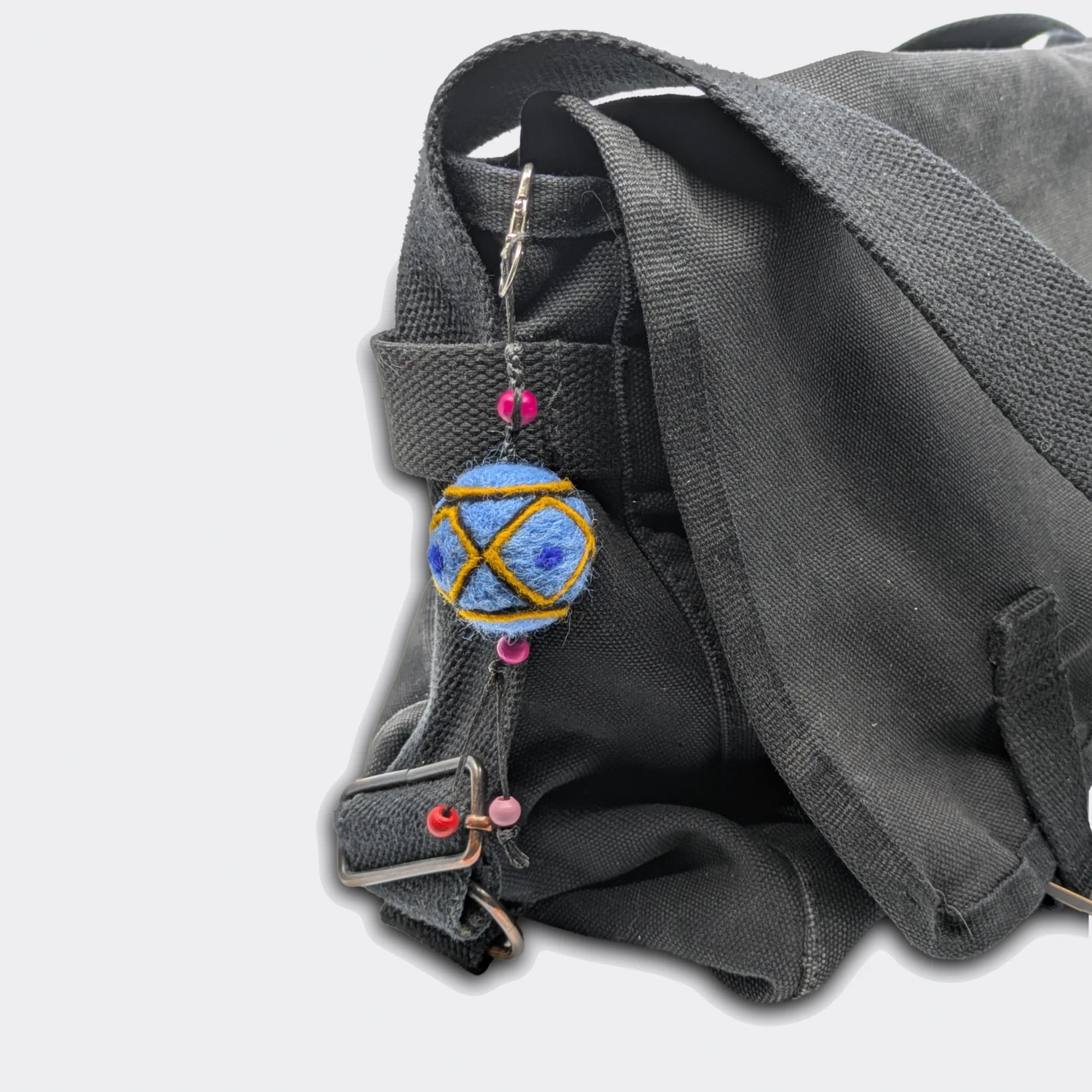 Breloque de sac Borka avec fond bleu attachée sur un sac