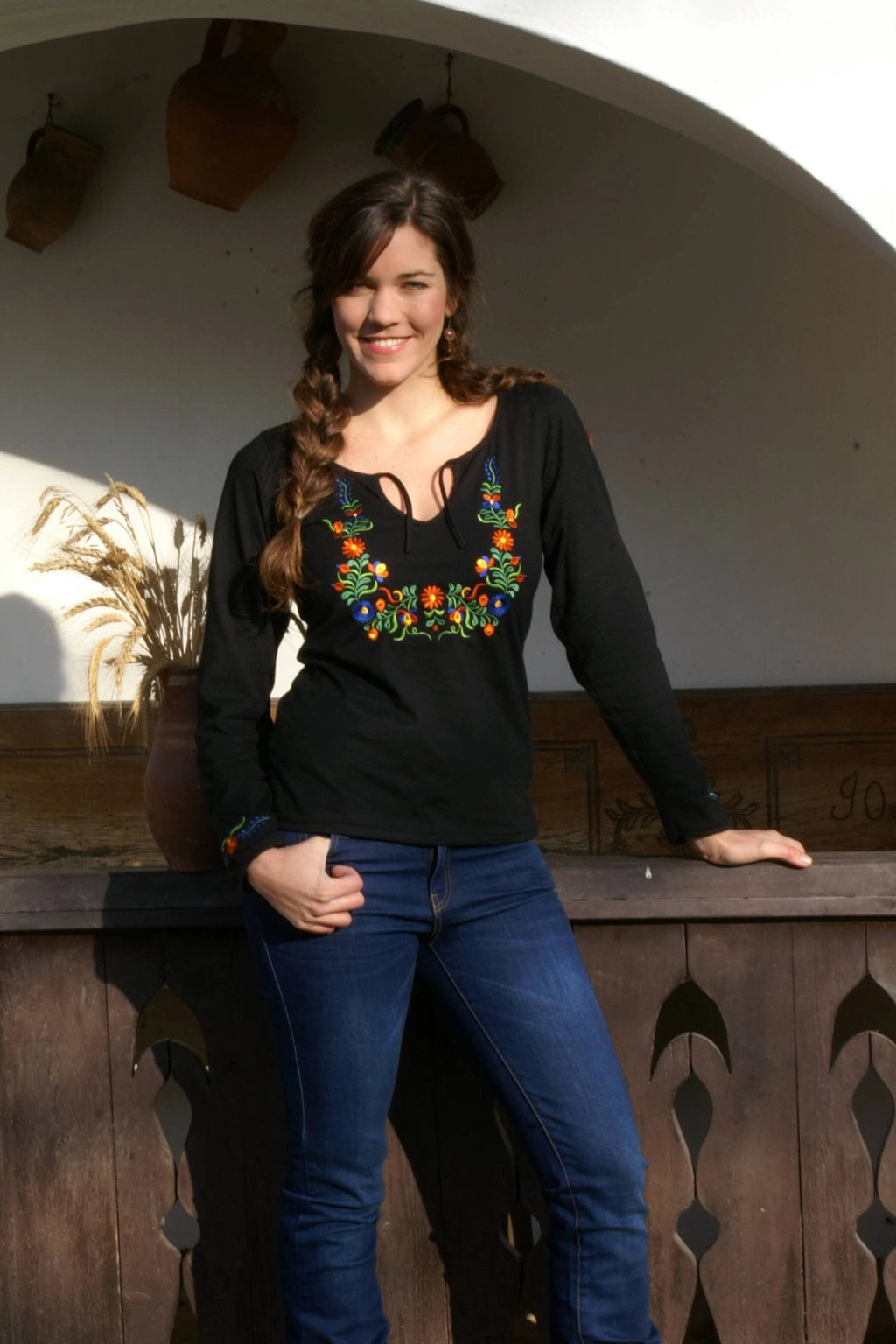 Haut noir pour femmes avec broderies colorées inspirées du style folklorique hongrois et plus exactement de la région de Béké, les motifs sont  disposés autour du col et sur les poignets. Vue de face, éloignée