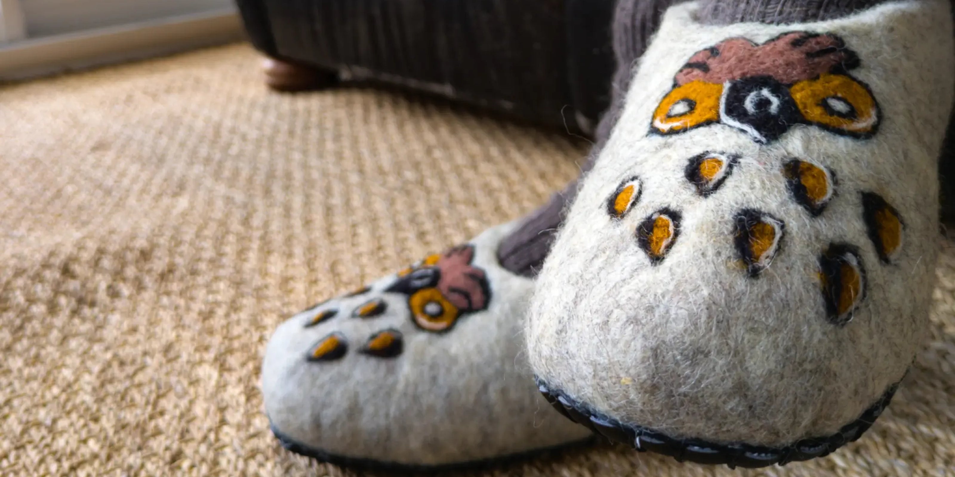 Detail de chaussons en feutre avec un motif de chouette stylisée
