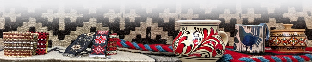 Bandeau de la page d'accueil avec un panacha de tasses géorgiennes et roumaines, bijoux, et tapis kilims 