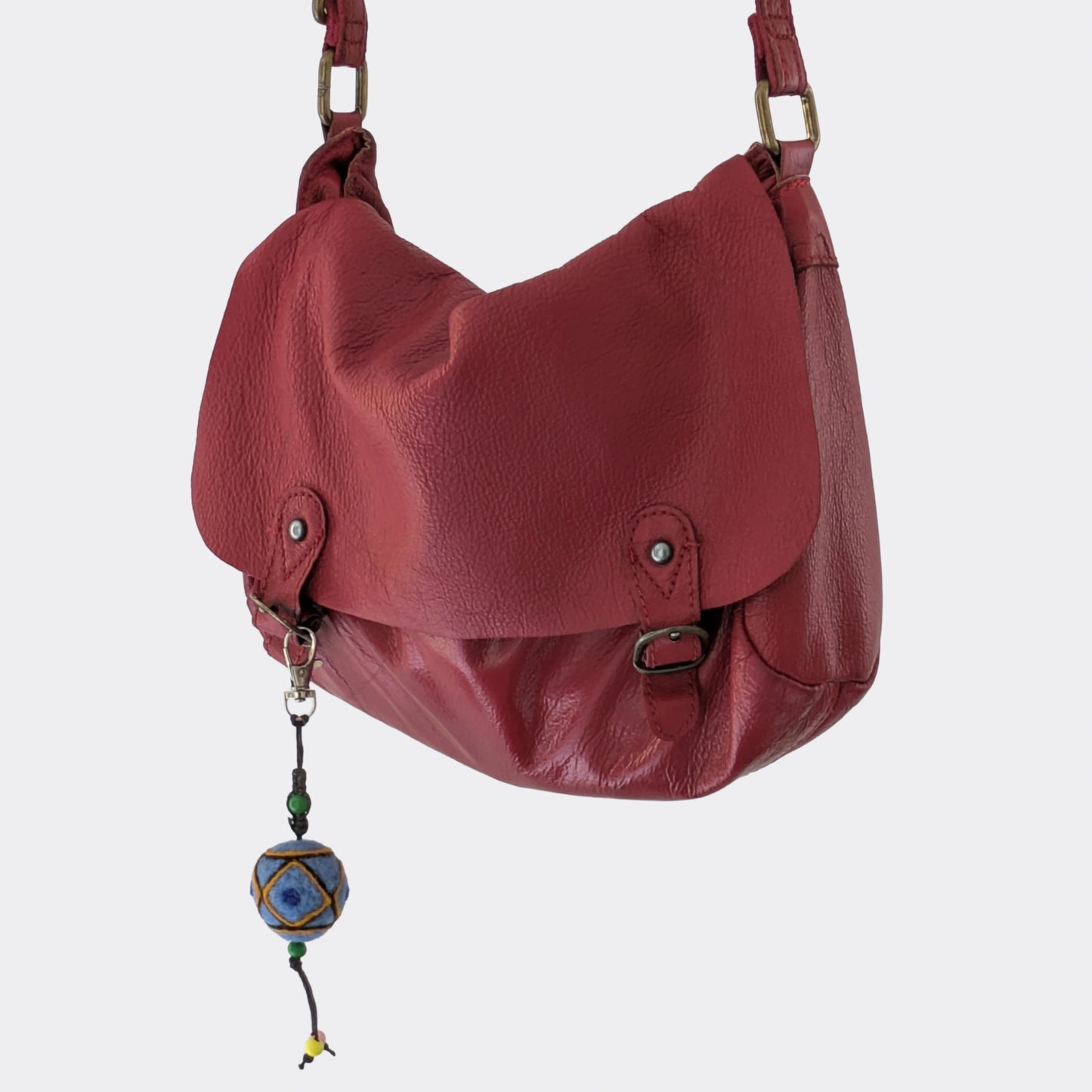 Bijou de sac avec motif traditionnel  bleu en feutre de laine sur sac rouge