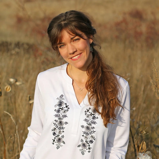 Blouse blanche pour femme, coupe ample, vêtement fluide, avec broderie Palóc grises-banches en colonnes florales délicates. Vue du buste.