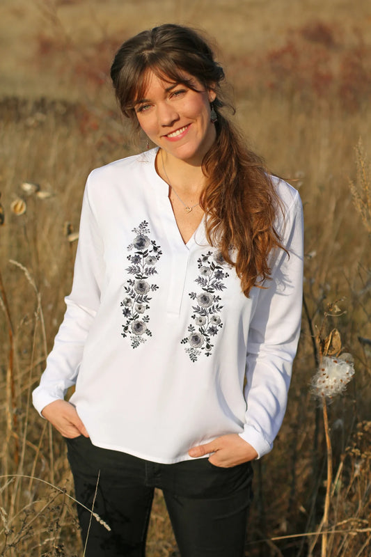 Blouse blanche ample et fluide pour femme. Agrémentée d'une magnifique broderie Palóc dans des tons gris-blancs très délicats.