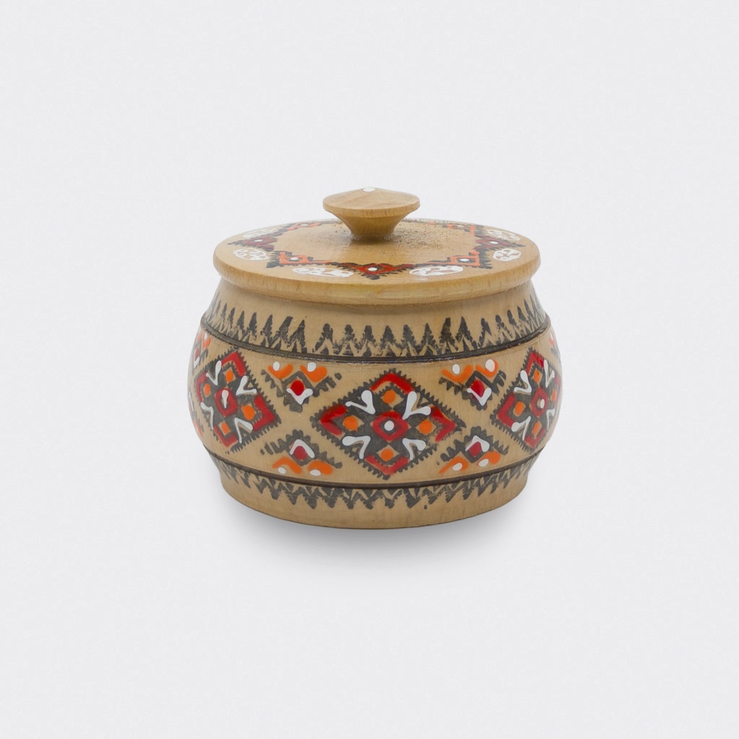 Boîte décorative en bois peinte à la main, aux motifs géométriques rouges et orangés. Cette boîte ukrainienne est un objet décoratif simple et fonctionnel.