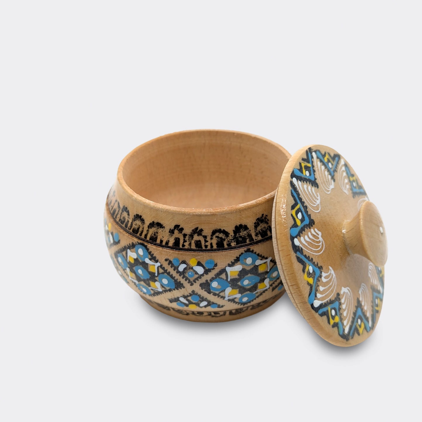 Boîte en bois peinte à la main, décor géométrique à dominante bleue. La peinture est appliquée manuellement.