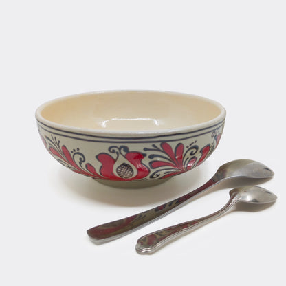 Grand bol en céramique de Corund présenté avec couverts, fond crème et motifs rouges traditionnels. Bol artisanal roumain 18 cm.