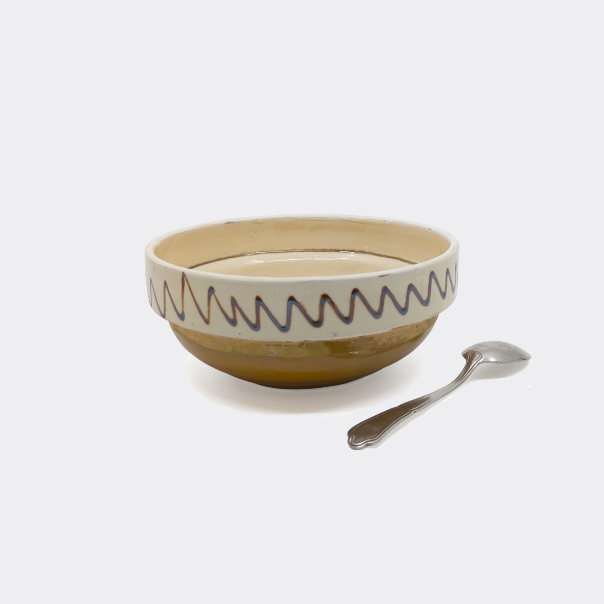 Bol en céramique traditionnelle de Corund, vue latérale. Frise extérieure sur fond crème, faïence artisanale.