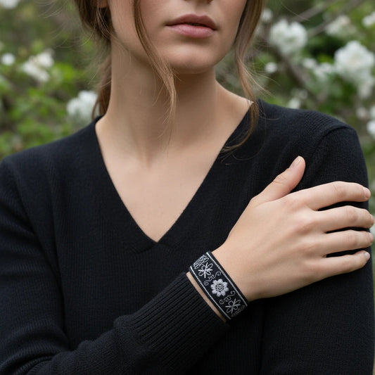 Bracelet brodé noir et argenté en coton, décoré de motifs floraux réalisés au point de chaînette et au point plein. Bijou artisanal inspiré du zlatovez