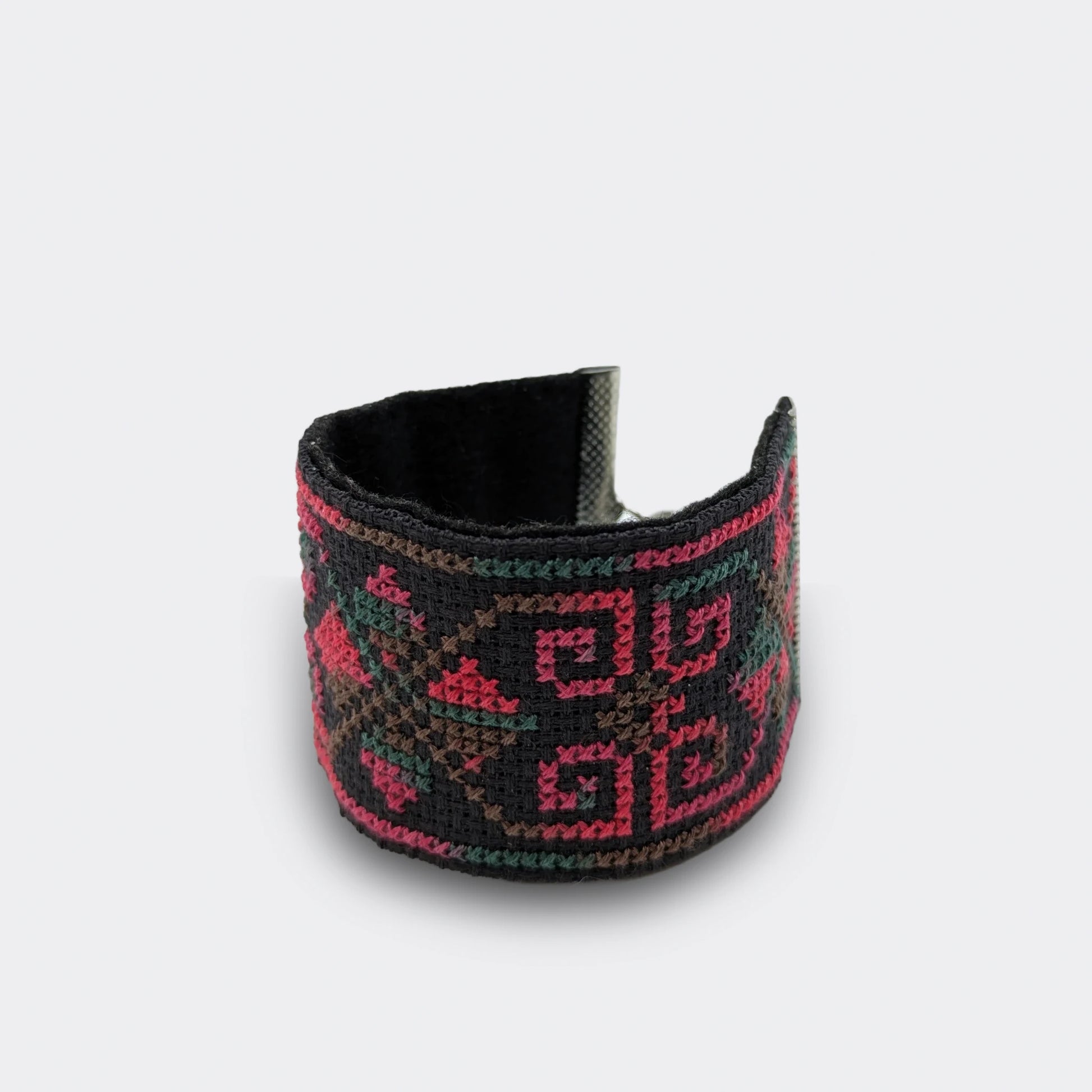 Détail d'un bracelet folklorique grenadine brodé sur toile Panama noire, orné de motifs balkaniques et doublé de feutre.