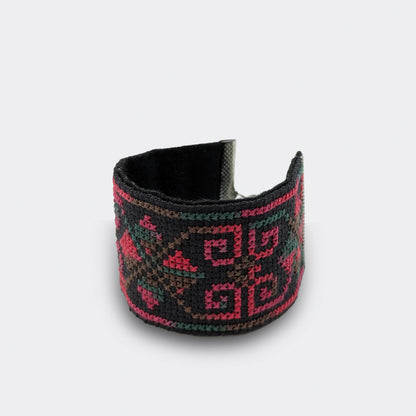 Détail d'un bracelet folklorique grenadine brodé sur toile Panama noire, orné de motifs balkaniques et doublé de feutre.