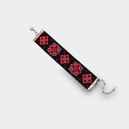 Vue à plat du bracelet artisanal et traditionnel noir et rouge de Serbie