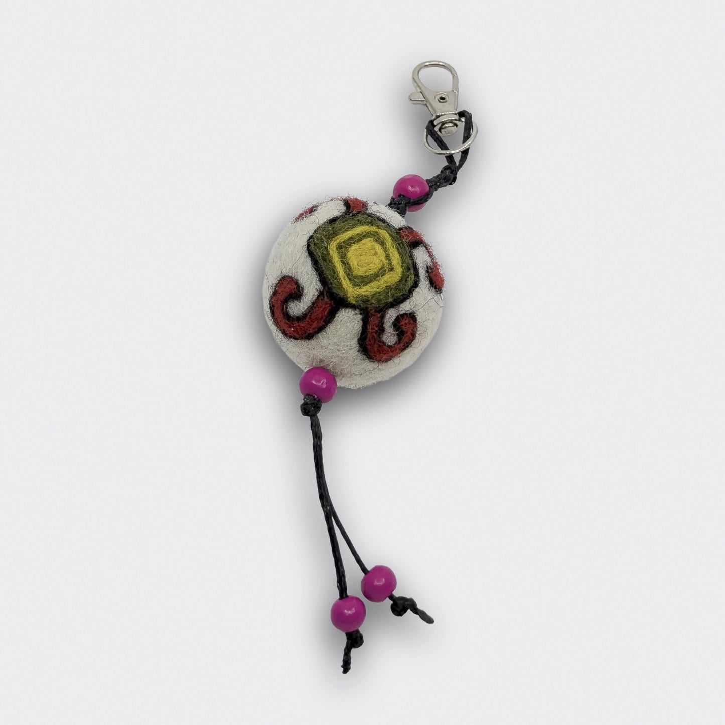 Breloque artisanale Mirna décorée d’une tortue rouge, jaune et verte inspirée des kilims de Pirot