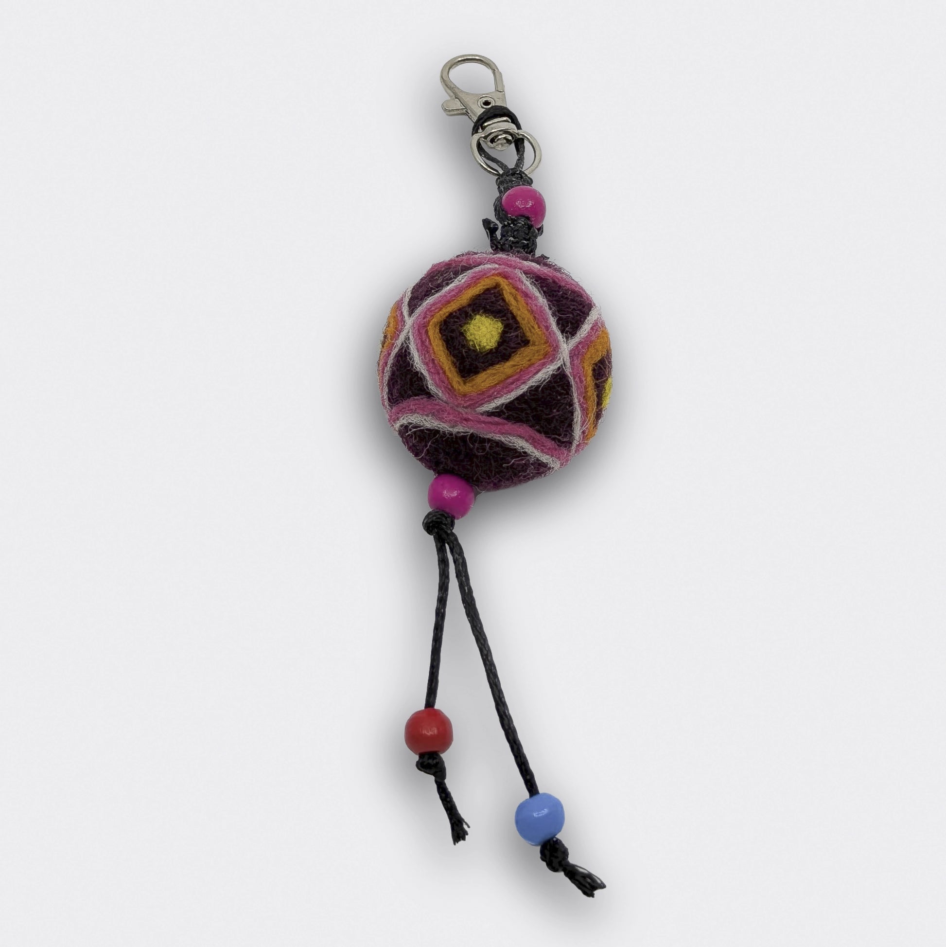 Breloque Bogdan constituée d'une boule en feutre rouge foncé et jaune entièrement faite à la main
