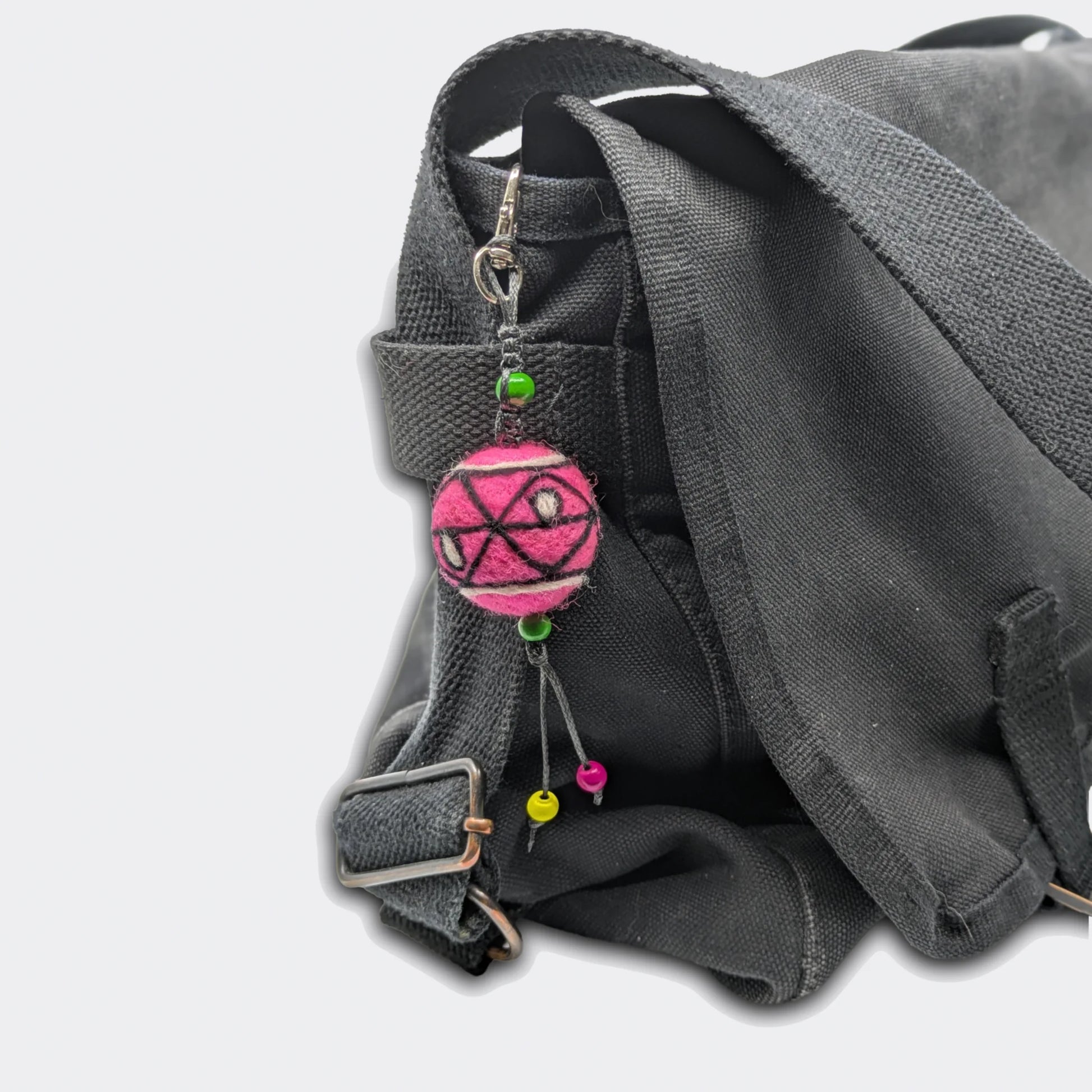 Breloque de sac Slavka avec une boule en feutre rose  attachée sur un sac