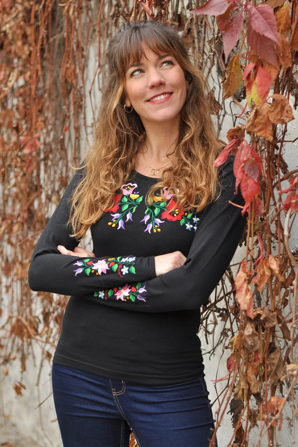 Vêtement féminin brodé Kalocsa floral, inspiration hongroise traditionnelle. Noir et à manches longues. Vue de face, un peu en biais