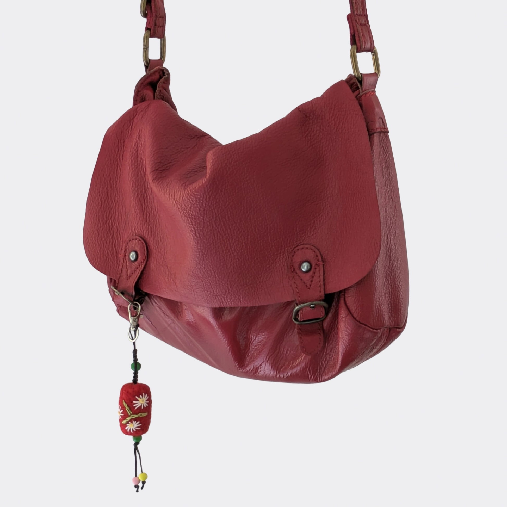 Charm artisanal serbe en laine feutrée accroché à un sac rouge