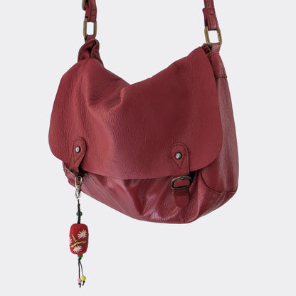 Charm artisanal serbe en laine feutrée accroché à un sac rouge
