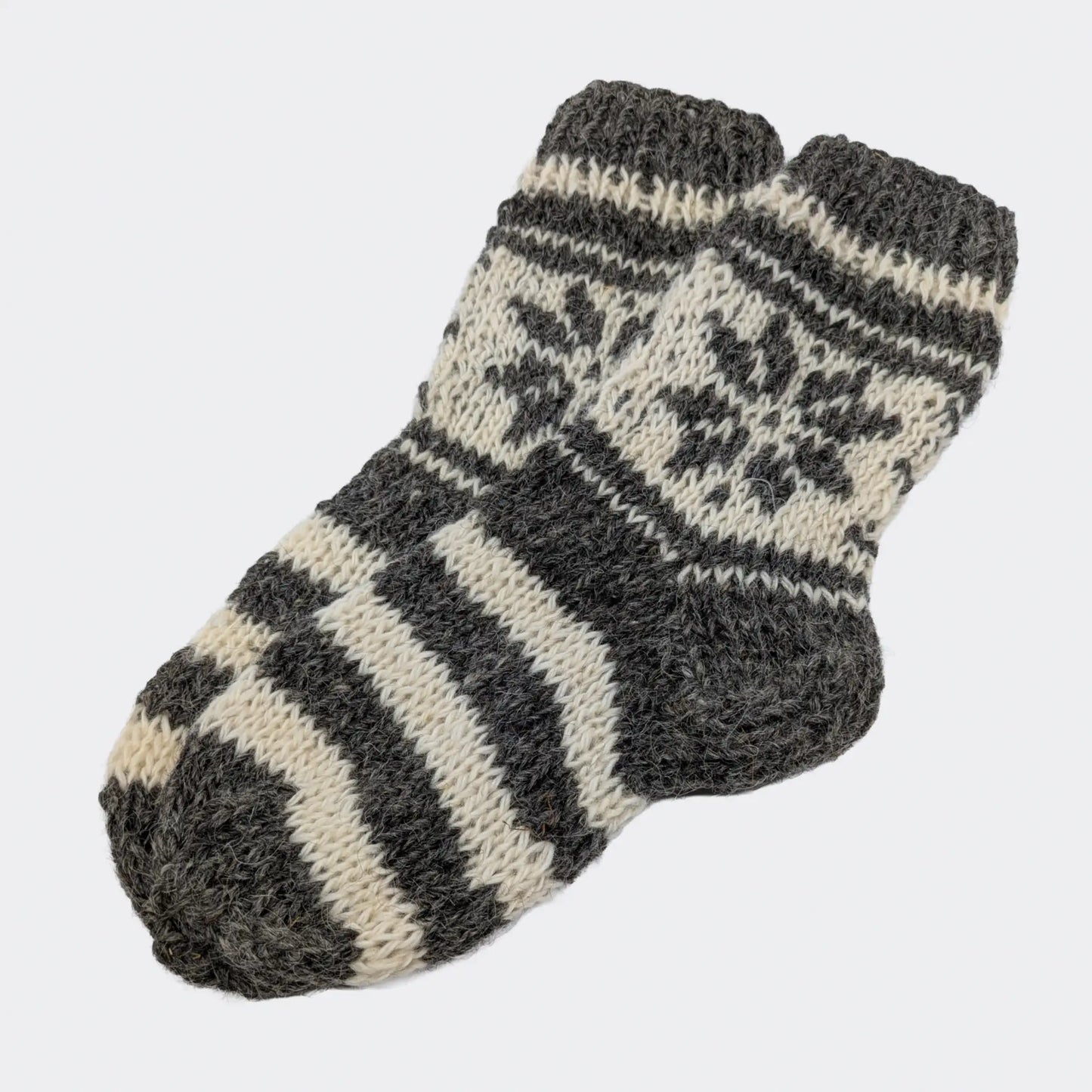 Chaussettes grises rayées en laine de mouton, avec pied rayé gris et écru. La tige présente un motif géométrique clair. Un modèle épais de chaussettes en laine du Podhale.