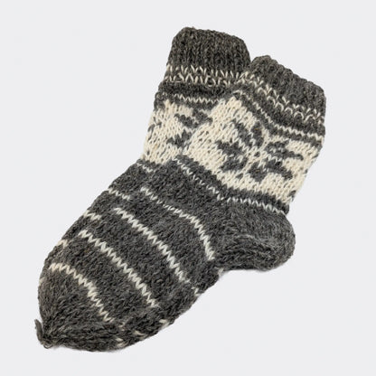 Variante de chaussettes grises rayées en laine de mouton, posées à plat. Le pied présente des rayures sobres. La tige porte un motif géométrique écru.