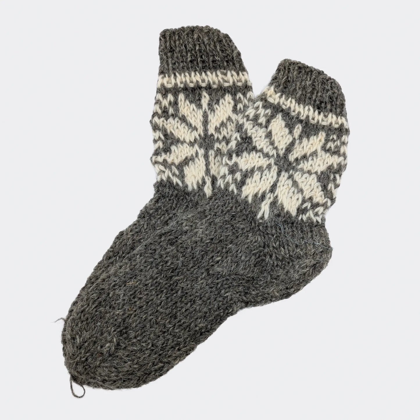 Chaussettes grises en laine avec motifs écrus sur la tige. Le pied reste uni, sans rayures. Modèle de chaussettes en laine de mouton à texture épaisse.