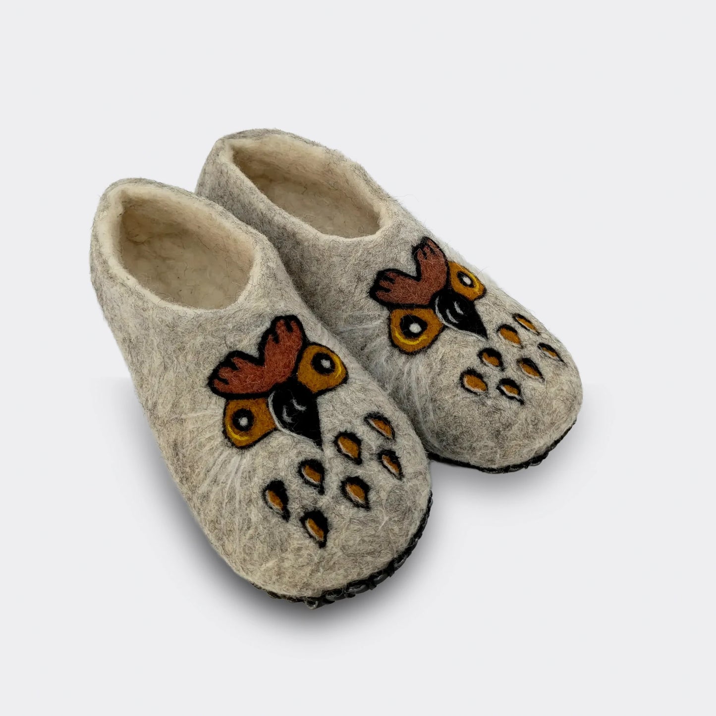 Chausson en feutre gris entièrement fait à la main décoré d’une chouette stylisée aux grands yeux, semelle antidérapante, vue de biais.