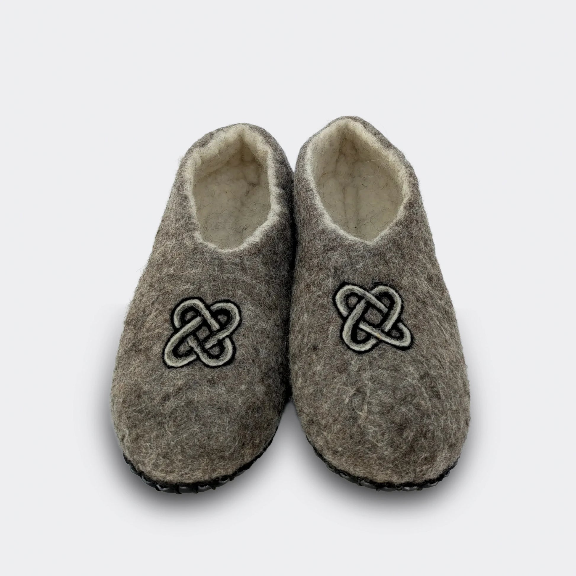 Chausson en feutre gris décoré du nœud de Salomon, symbole ancien d’éternité, fait main en Serbie, présenté en vue de face.