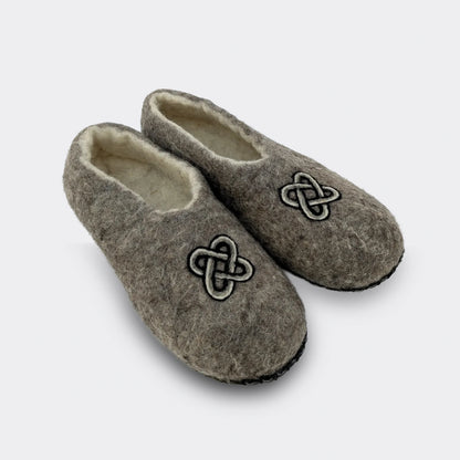 Chausson artisanal en feutre gris, motif traditionnel du nœud de Salomon, fabriqué main, photographié en vue de biais.