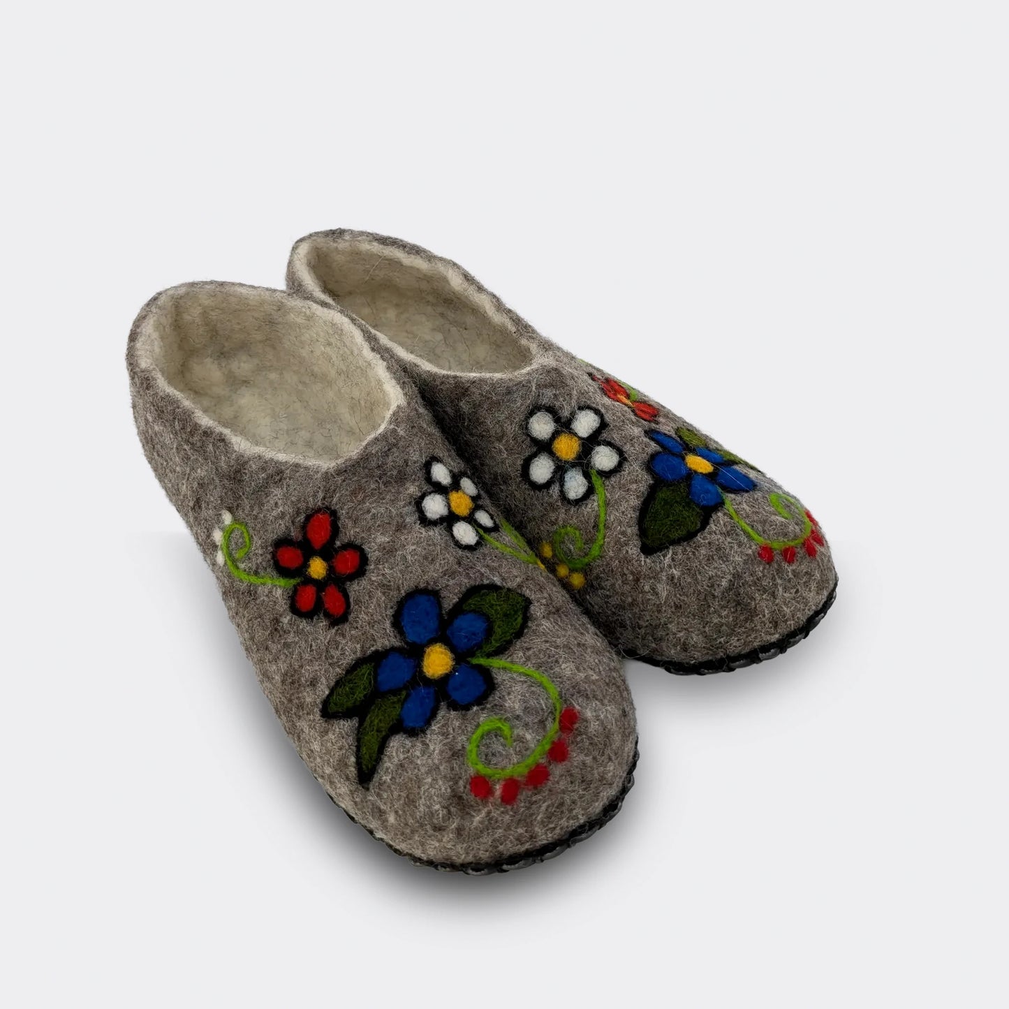 Chausson en laine feutrée grise décorée de fleurs multicolores, chaleur et confort de la laine naturelle – vue de biais.