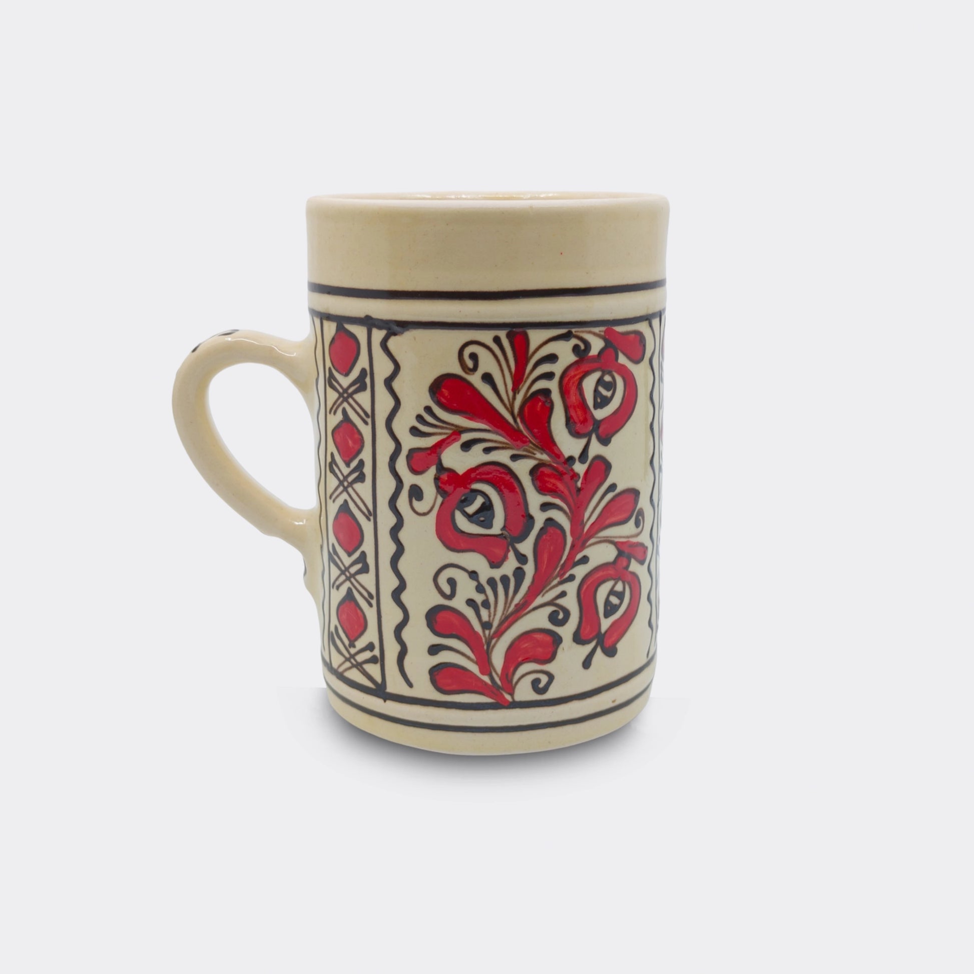 Chope en céramique de Corund avec décor floral rouge peint à la main sur fond crème émaillé. Faïence artisanale roumaine.