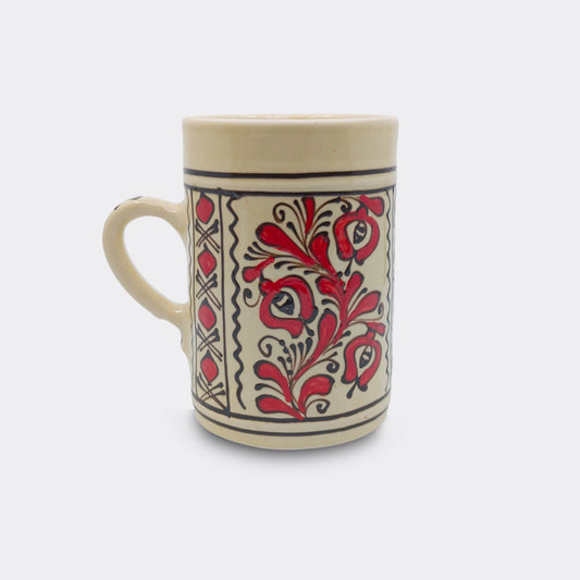 Chope en céramique de Corund avec décor floral rouge peint à la main sur fond crème émaillé. Faïence artisanale roumaine.