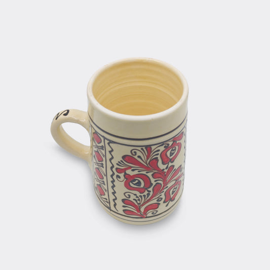 Chope traditionnelle de Corund au décor floral rouge sur glaçure crème.