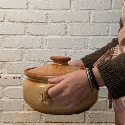 Cocotte artisanale de Corund 5 litres tenue dans les mains, poterie traditionnelle pour cuisine familiale et plats mijotés.