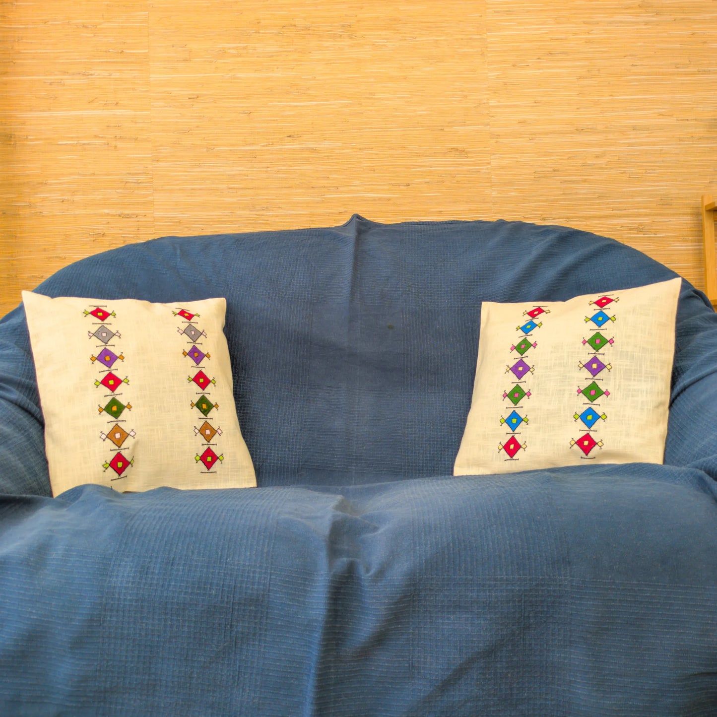 Housses de coussins en lin brodées de losanges serbes posé sur un canapé.