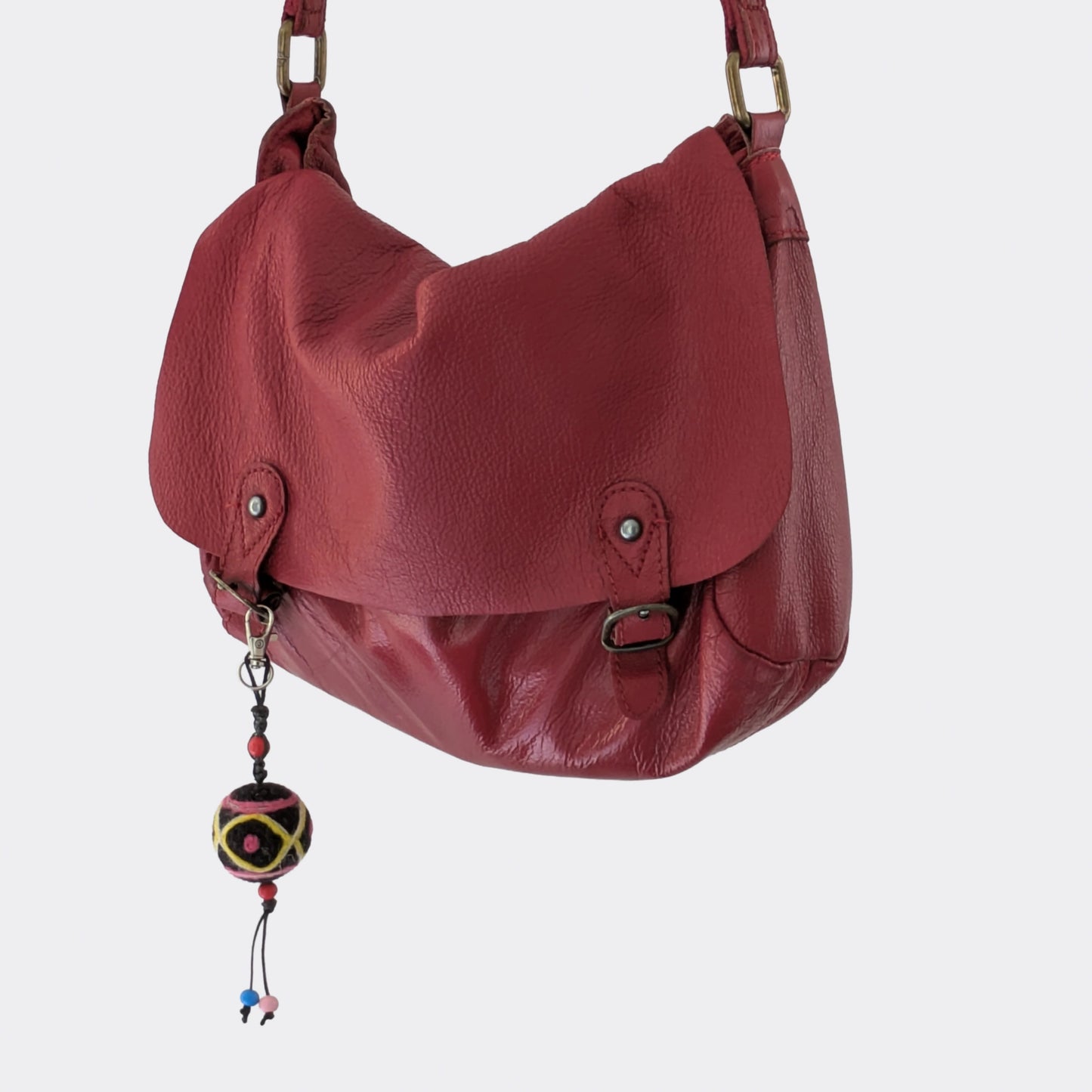 Déco de sac en feutre artisanal accrochée à un sac rouge