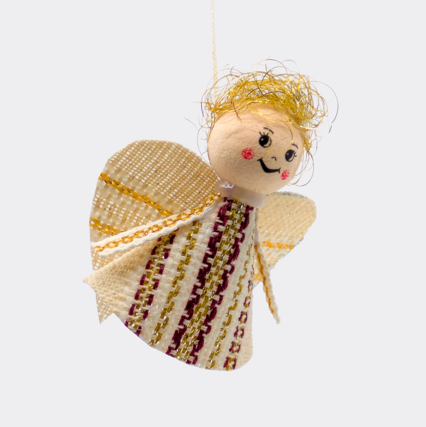 Petit ange décoratif en tissu bordeaux et fils dorés, silhouette simple et lumineuse. Une figurine inspirée des traditions d’Europe centrale.